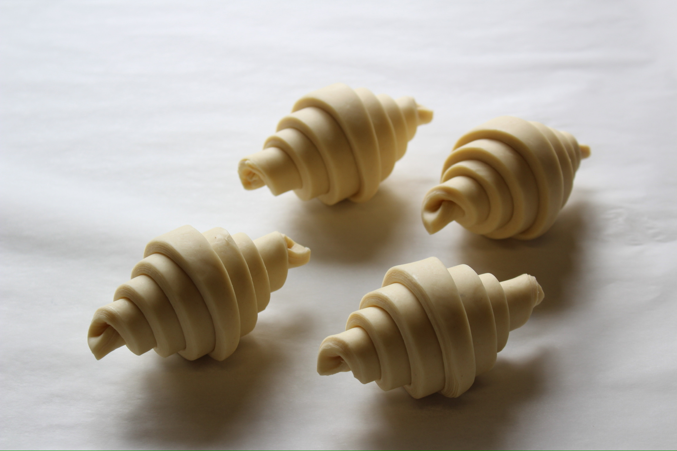 Four unbaked croissants on a counter | Kave Bakery